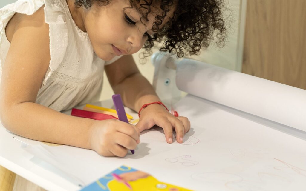 Niña pintando con colores desarrolando su creatividad 