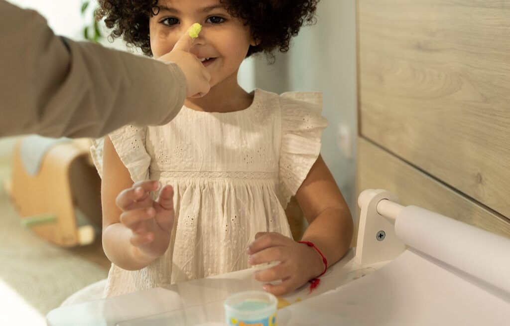 Niña pintándose la cara con pintura