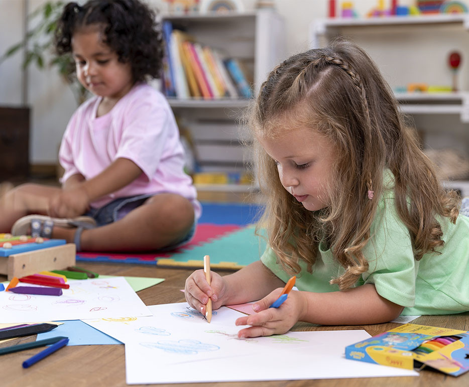 Niñas pintando sobre papel con ceras