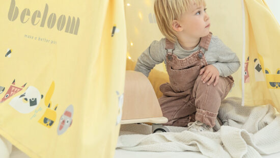 Niño jugando en casa con un tipi infantil.