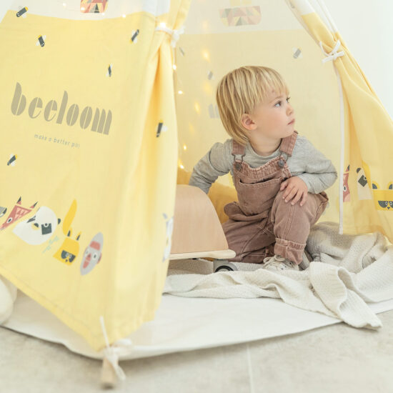 Niño jugando en casa con un tipi infantil.